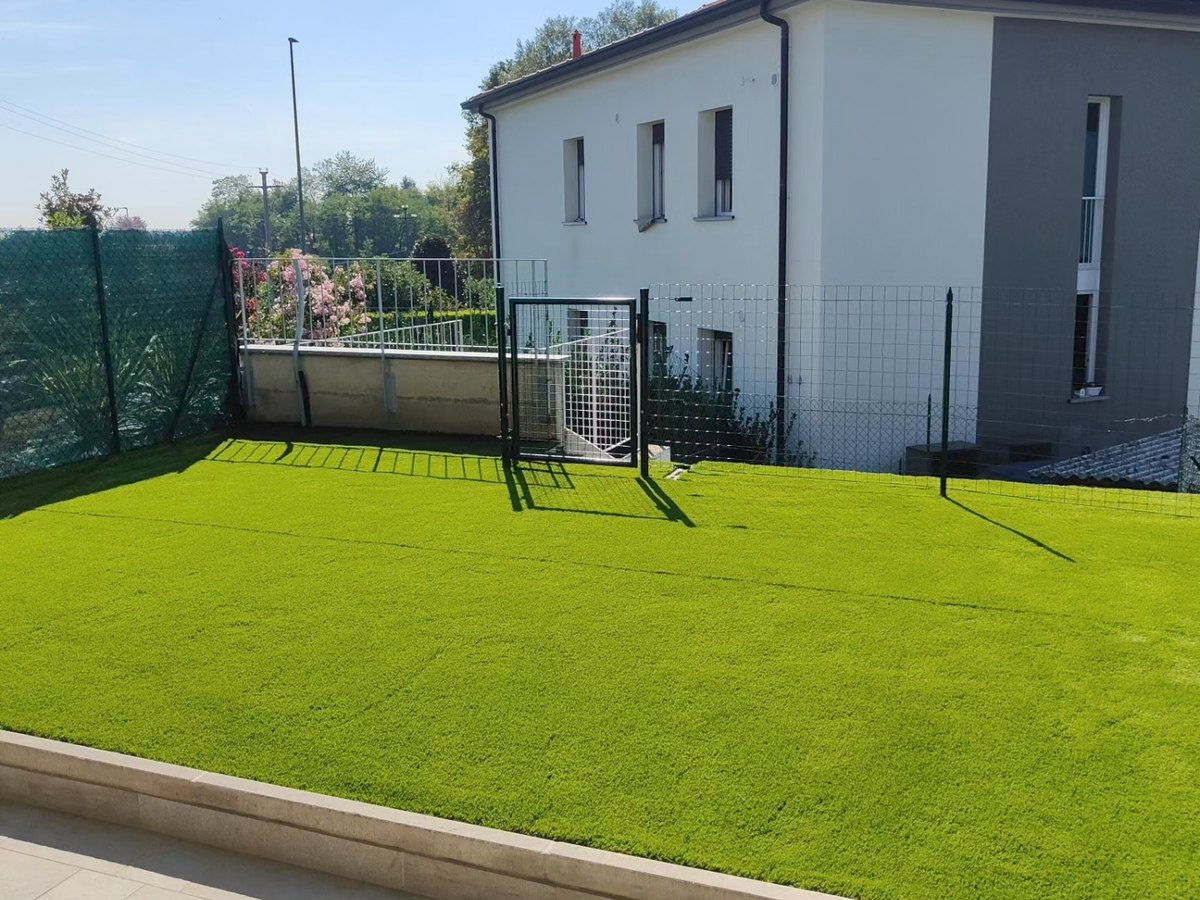 Prato sintetico posato in un giardino recintato